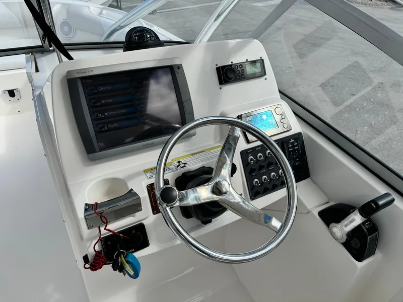 Slide: The Image of Edgewater 245 CX 2013 boat dashboard with steering wheel and navigation controls. - 24