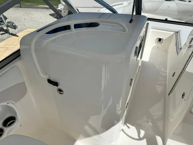 Slide: The Image of 2013 Edgewater 245 CX boat interior with sleek white design and storage compartments. - 26