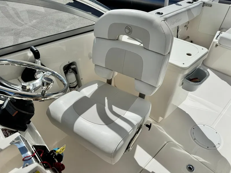 Slide: The Image of Edgewater 245 CX 2013 boat interior with white captain's chair and steering wheel. - 28
