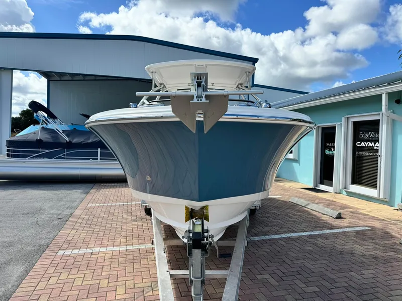 Slide: The Image of 2013 Edgewater 245 CX boat on trailer, parked outdoors under a blue sky. - 3