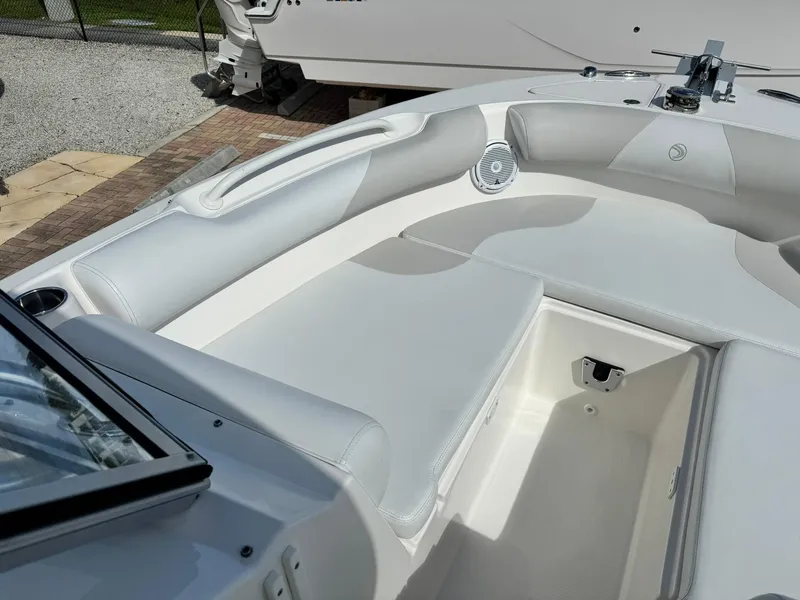 Slide: The Image of 2013 Edgewater 245 CX boat interior with white seating and storage compartment. - 31