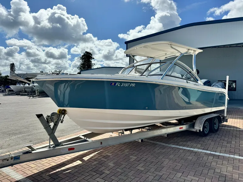 Slide: The Image of 2013 Edgewater 245 CX boat on trailer under cloudy sky. - 4