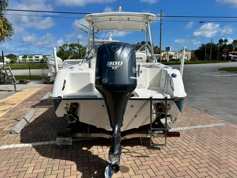 Slide: The Image of 2013 Edgewater 245 CX boat with 300 V6 engine, parked on brick pavement. - 5