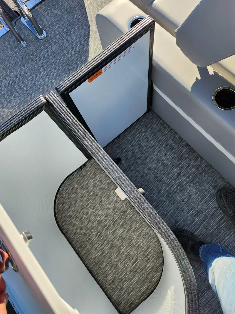 Slide: The Image of 2024 Crest Classic Platinum 220 boat interior with storage compartment and seating. - 17