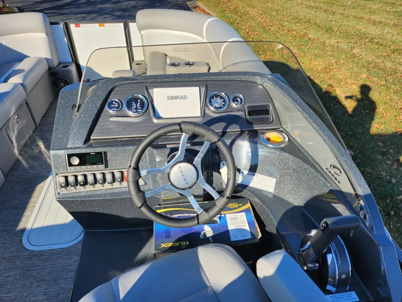 Slide: The Image of 2024 Crest Classic Platinum 220 boat dashboard with steering wheel and controls. - 21