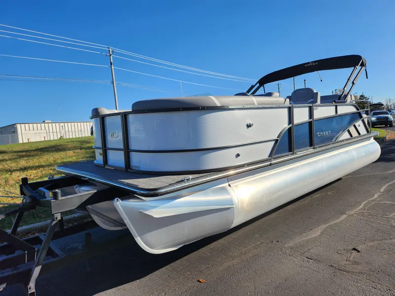 Slide: The Image of 2024 Crest Classic Platinum 220 pontoon boat on trailer, sunny day. - 5