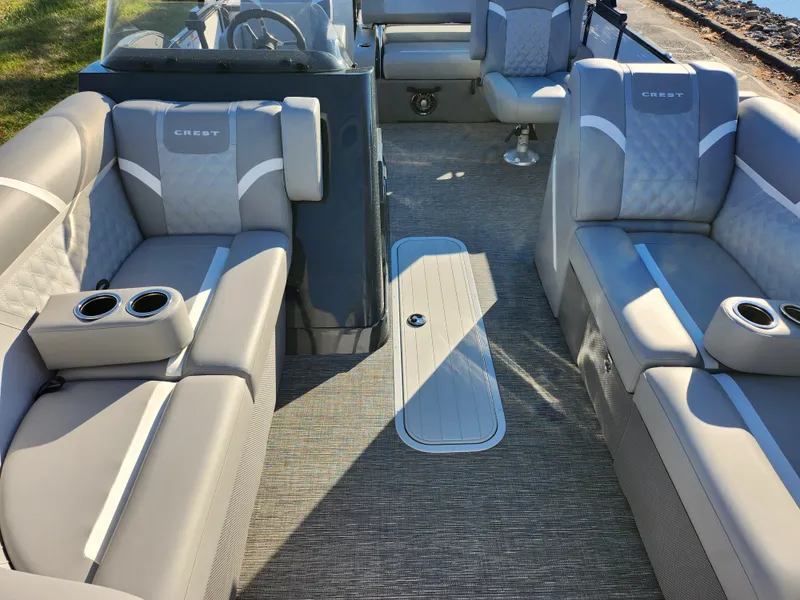 Slide: The Image of 2024 Crest Classic Platinum 220 boat interior with luxurious seating and cup holders. - 9