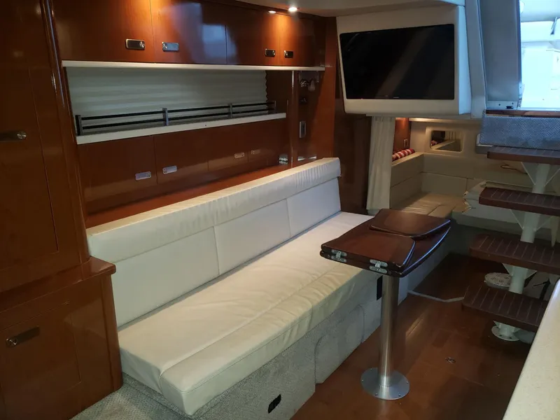 Slide: The Image of Interior of 2011 Sea Ray 350 Sundancer yacht with white seating and wooden accents. - 14