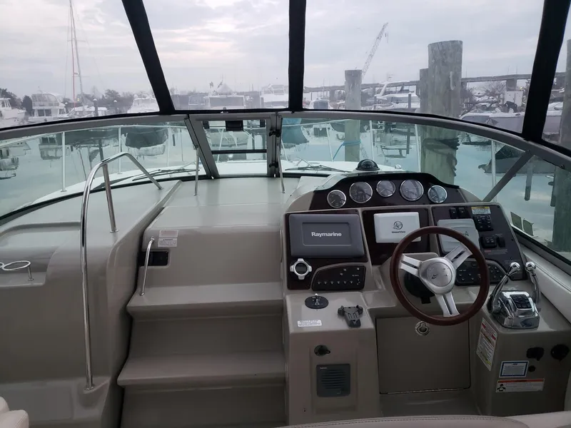 Slide: The Image of 2011 Sea Ray 350 Sundancer helm with modern navigation equipment and spacious cockpit. - 3