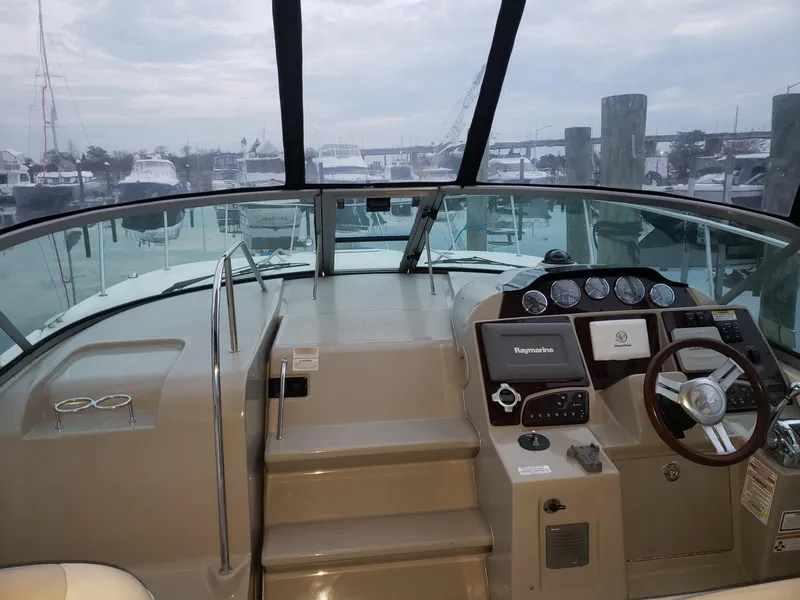 Slide: The Image of 2011 Sea Ray 350 Sundancer boat cockpit with steering wheel and dashboard, docked at marina. - 4