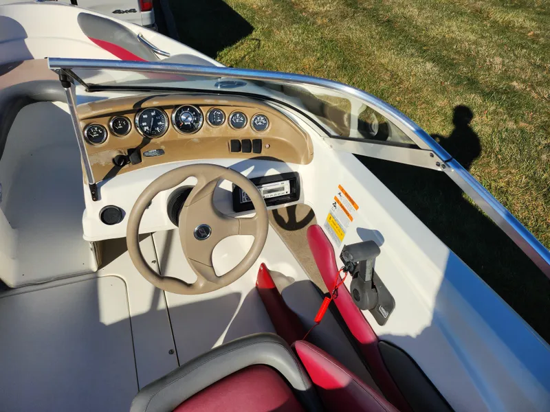 Slide: The Image of 2003 Larson SEi 180 boat dashboard with steering wheel and gauges. - 12