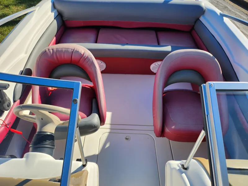 Slide: The Image of 2003 Larson SEi 180 boat interior with red seats and steering wheel. - 18
