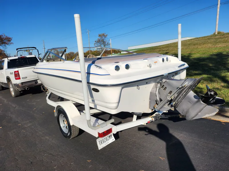 Slide: The Image of 2003 Larson SEi 180 boat on trailer, parked on road, sunny day. - 3