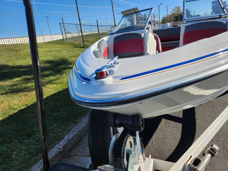 Slide: The Image of 2003 Larson SEi 180 boat on trailer, white with red interior, parked outdoors. - 6