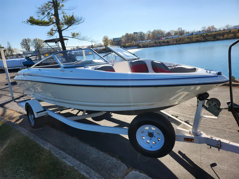 Slide: The Image of 2003 Larson SEi 180 boat on trailer by a lakeside. - 8