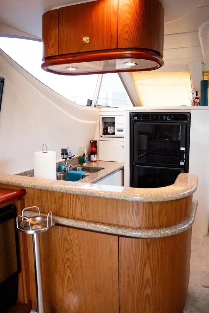 Slide: The Image of 1999 Maxum 4100 SCR yacht kitchen with wood cabinetry and modern appliances. - 12