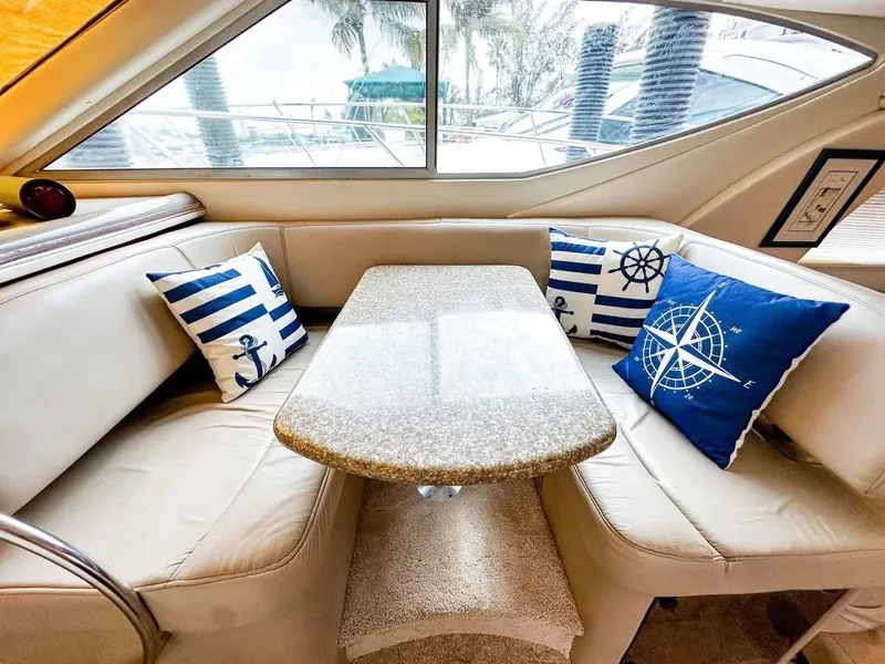 Slide: The Image of Interior of 1999 Maxum 4100 SCR yacht with nautical-themed cushions and sleek table. - 15