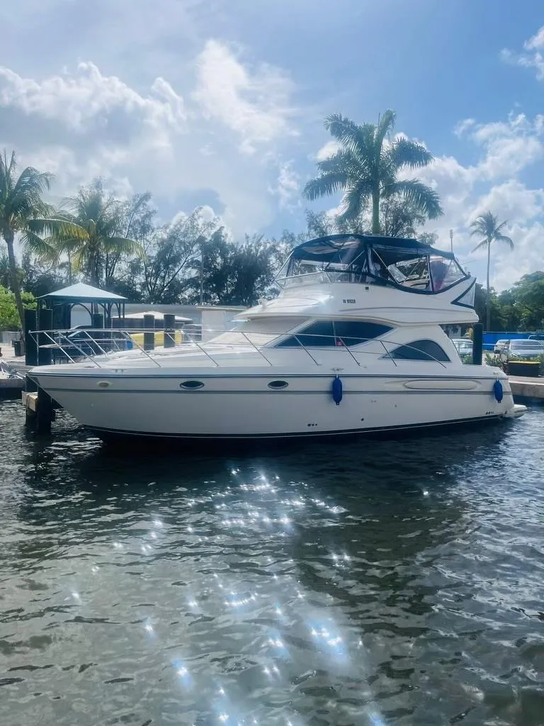 Slide: The Image of 1999 Maxum 4100 SCR yacht docked on sunny day with palm trees. - 3