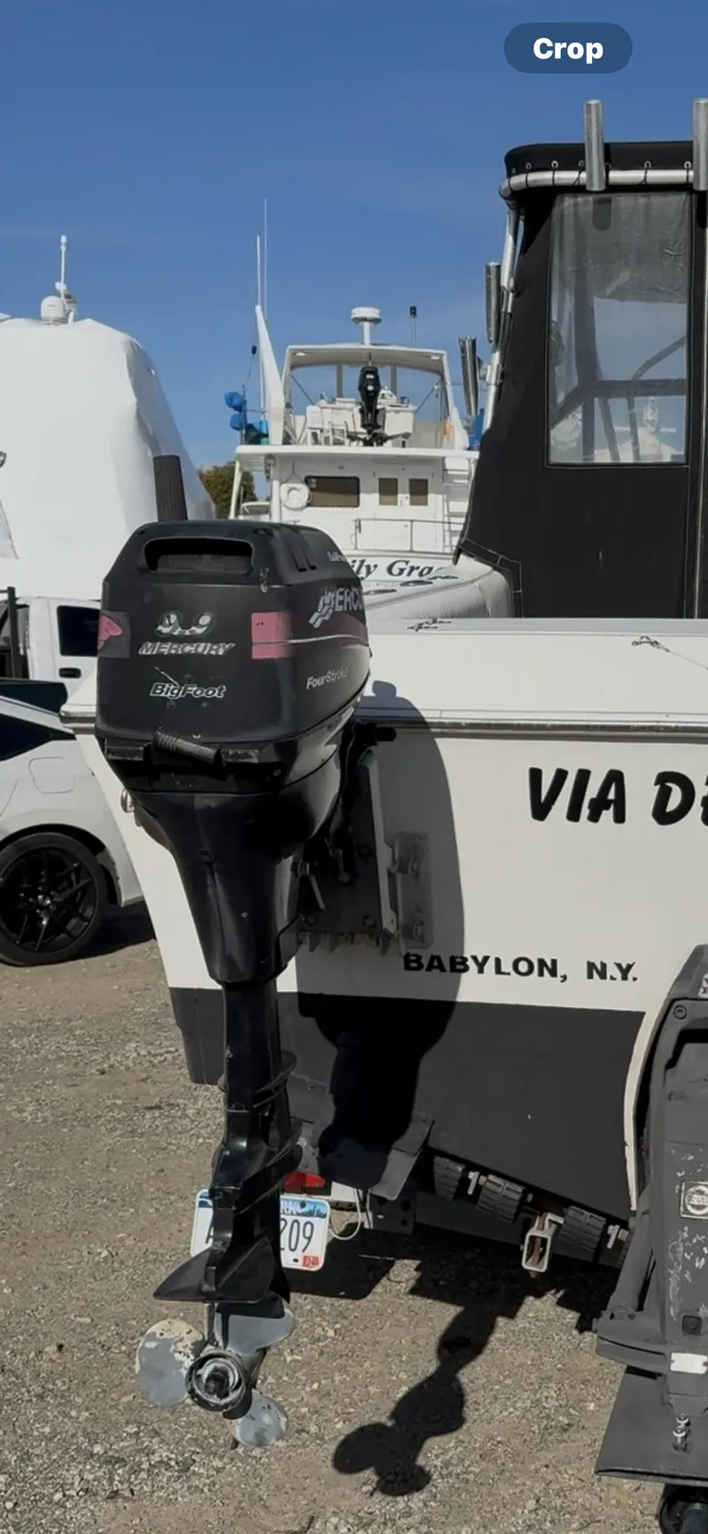 The Image of 1998 Sport-Craft 252 Sportfish boat on trailer under clear blue sky. - 1