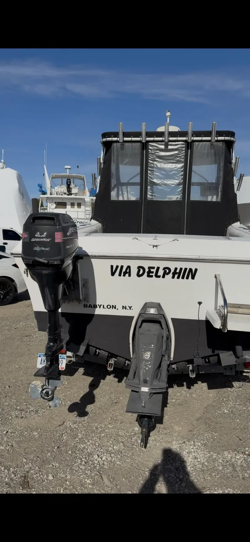Slide: The Image of 1998 Sport-Craft 252 Sportfish boat on trailer, parked near marina under blue sky. - 3