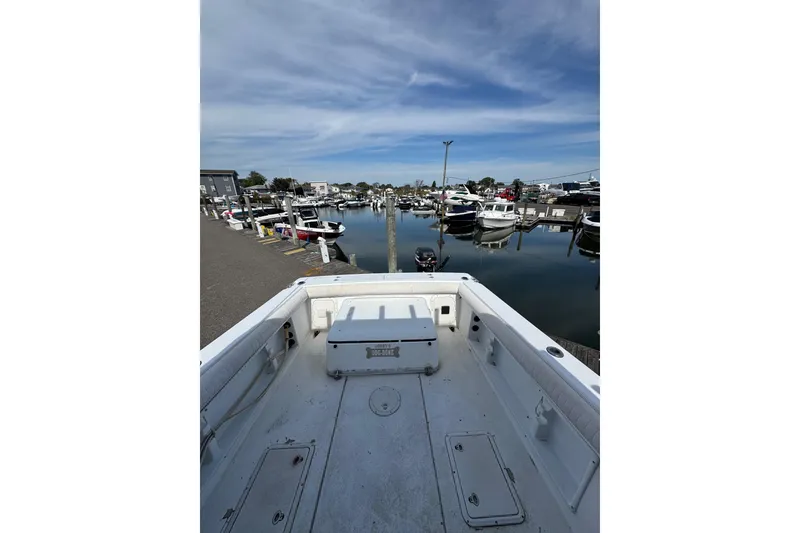 Slide: The Image of 1998 Sport-Craft 252 Sportfish boat docked at a marina under a clear sky. - 7