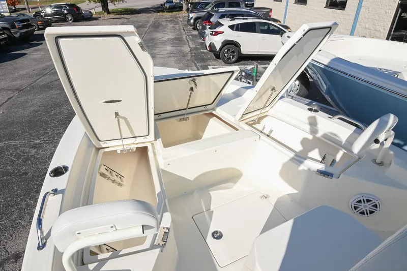 Slide: The Image of 2025 Pathfinder 2200 TRS boat with open storage compartments in a parking lot. - 27
