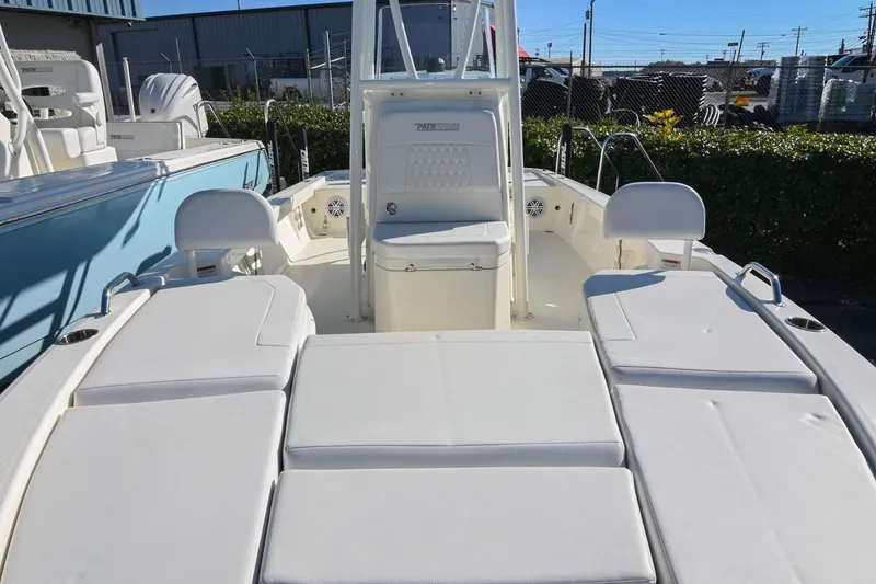 Slide: The Image of 2025 Pathfinder 2200 TRS boat interior with white seating and console, docked outdoors. - 30