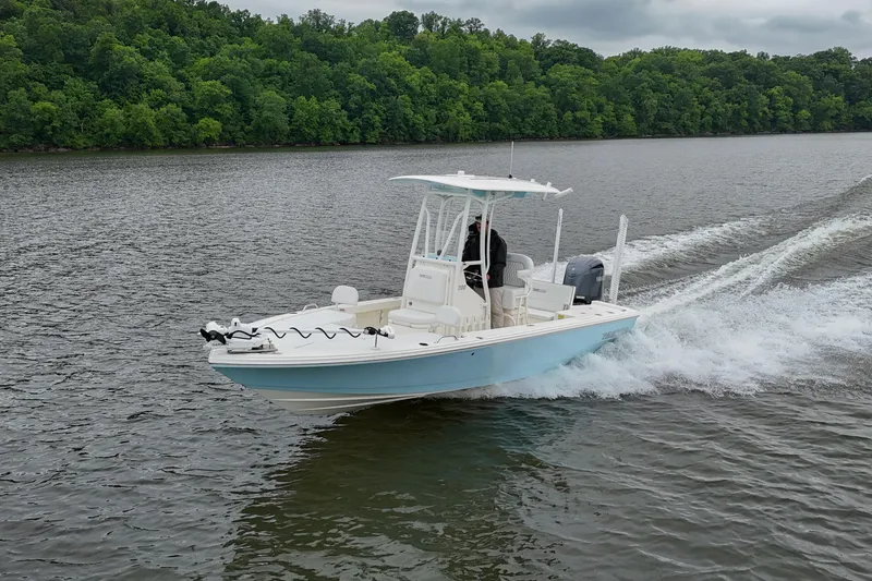 Slide: The Image of 2025 Pathfinder 2200 TRS boat cruising on a scenic river. - 35