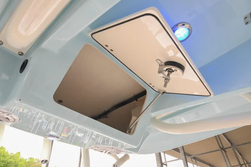 Slide: The Image of 2025 Pathfinder 2200 TRS boat storage compartment with blue LED light and open hatch. - 38