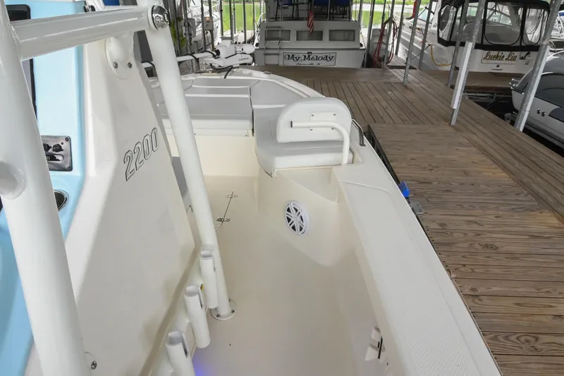 Slide: The Image of 2025 Pathfinder 2200 TRS boat docked, showcasing interior seating and deck features. - 41