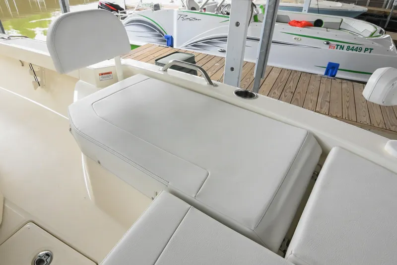 Slide: The Image of 2025 Pathfinder 2200 TRS boat interior with cushioned seating and docked boats in background. - 47