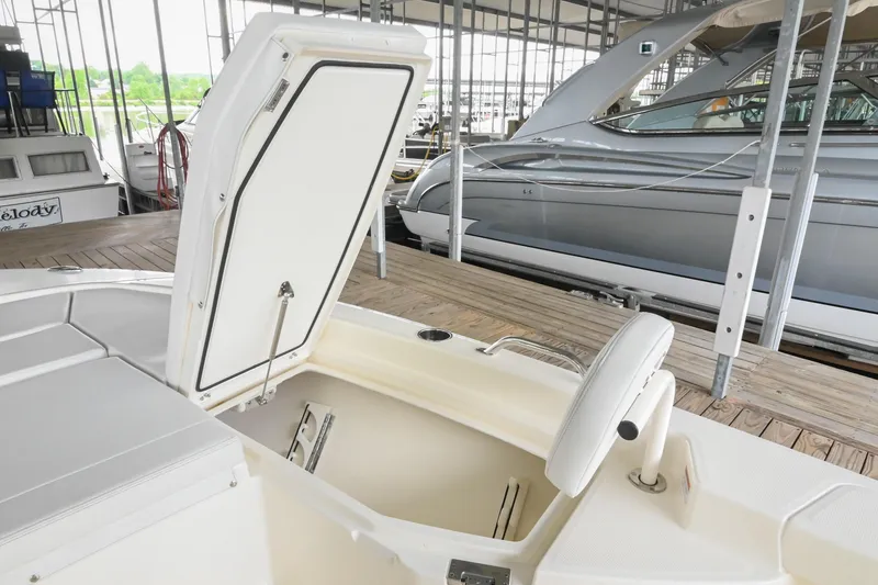 Slide: The Image of 2025 Pathfinder 2200 TRS boat with open storage compartment in marina setting. - 50