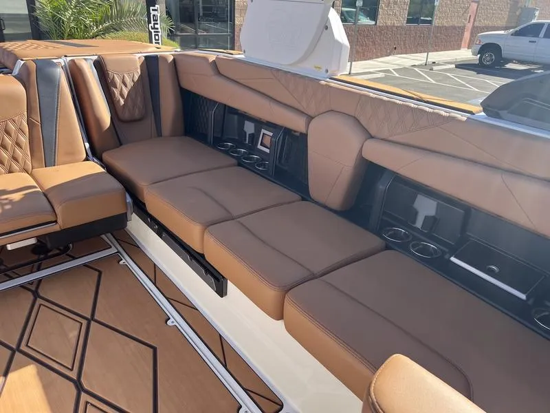 Slide: The Image of 2025 Malibu M230 boat interior with brown leather seating and modern design. - 16