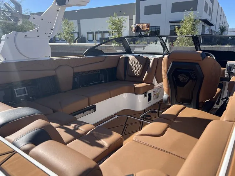 Slide: The Image of 2025 Malibu M230 boat interior with luxurious brown leather seating and modern design. - 17