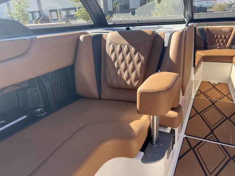 Slide: The Image of Luxurious interior of 2025 Malibu M230 boat with tan leather seating and diamond stitching. - 21
