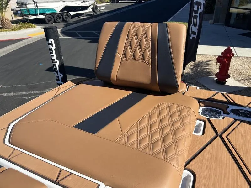 Slide: The Image of 2025 Malibu M230 boat seat with tan and black leather upholstery, featuring diamond stitching. - 26