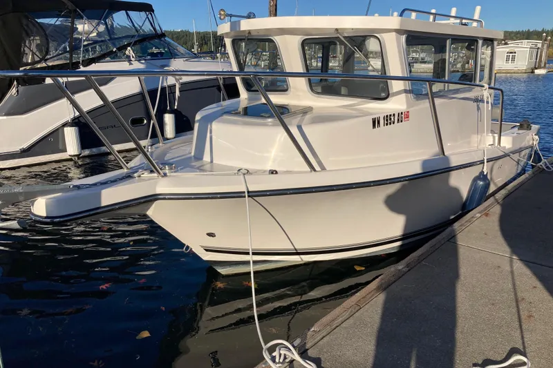 The Image of 2023 Defiance San Juan 220 boat docked at marina under clear sky. - 0