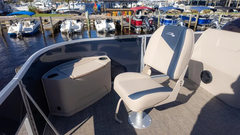 Slide: The Image of 2025 Bennington 21SF boat interior with seating, docked at marina. - 10