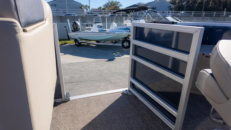 Slide: The Image of 2025 Bennington 21SF boat interior with open gate, showing parked boat outside. - 21