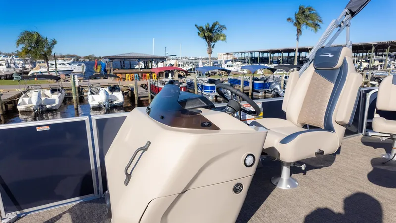 Slide: The Image of 2025 Bennington 21SF pontoon boat at marina, featuring helm and captain's chair. - 22