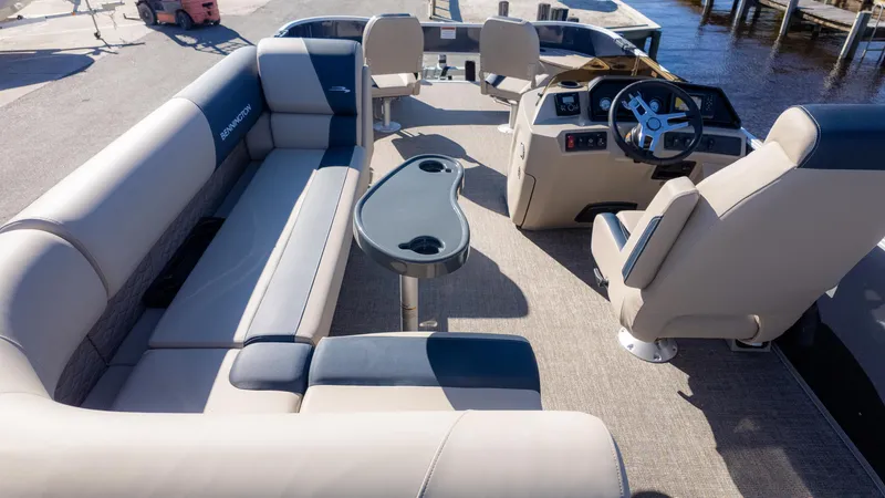 Slide: The Image of 2025 Bennington 21SF pontoon boat interior with beige seating and steering console. - 6