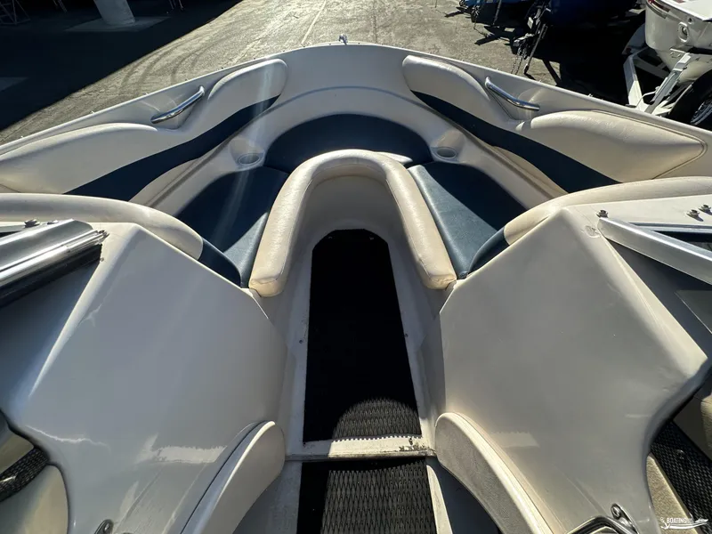 Slide: The Image of Interior view of a 2002 Larson 210 SEI boat, featuring cushioned seating. - 12