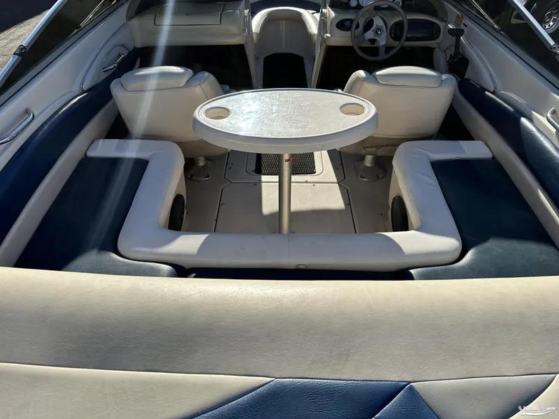 Slide: The Image of Interior of a 2002 Larson 210 SEI boat with seating and table. - 13