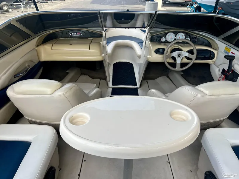 Slide: The Image of Interior of a 2002 Larson 210 SEI boat with white seating and steering console. - 5