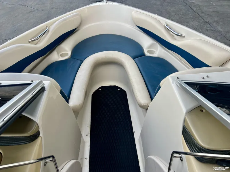 Slide: The Image of 2002 Larson 210 SEI boat interior with blue and white seating. - 6