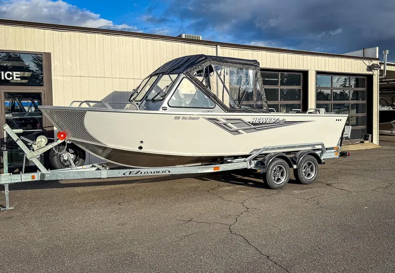 Slide: The Image of 2025 Hewescraft 210 Sea Runner ET boat on trailer outside a building. - 1