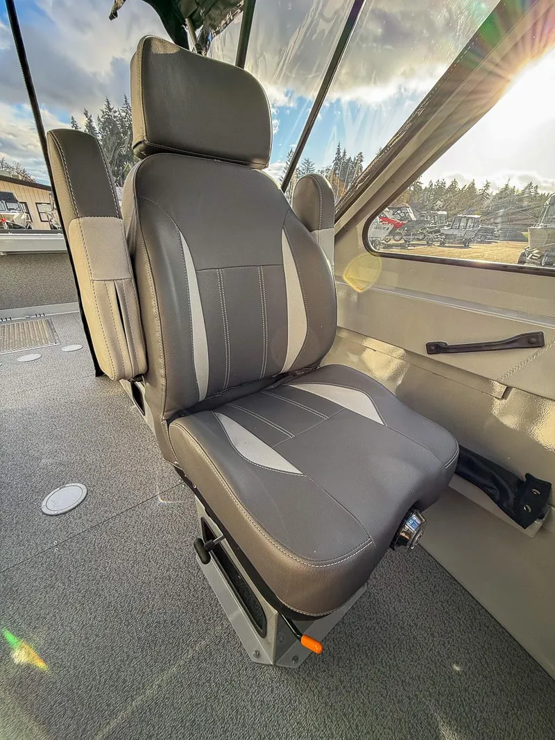 Slide: The Image of 2025 Hewescraft 210 Sea Runner ET interior seat with gray upholstery and sunlight. - 10