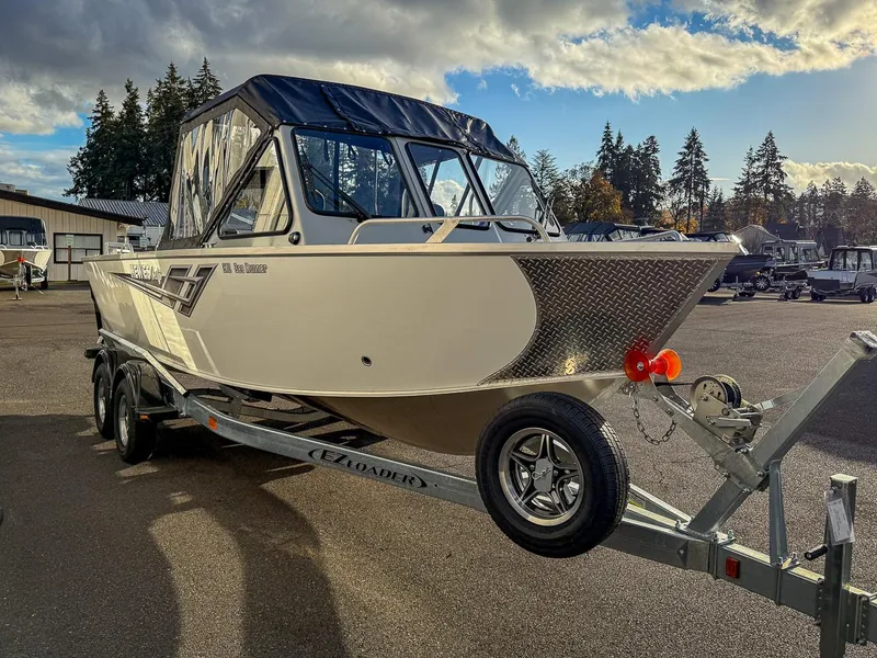 Slide: The Image of 2025 Hewescraft 210 Sea Runner ET boat on trailer under cloudy sky. - 6