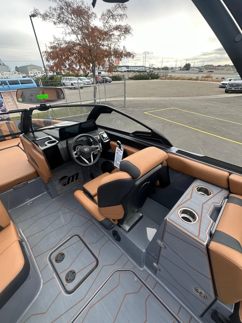 Slide: The Image of 2025 Malibu 24 MXZ boat interior with modern dashboard and tan seating. - 18
