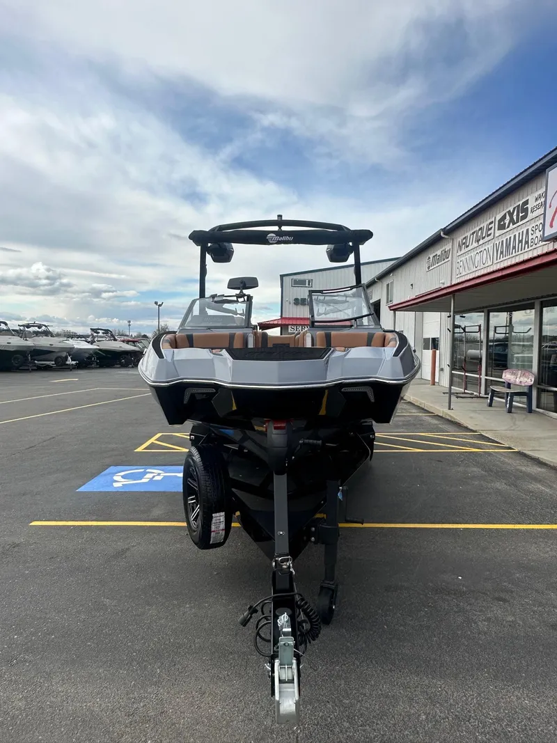 Slide: The Image of 2025 Malibu 24 MXZ boat on trailer at dealership parking lot. - 5
